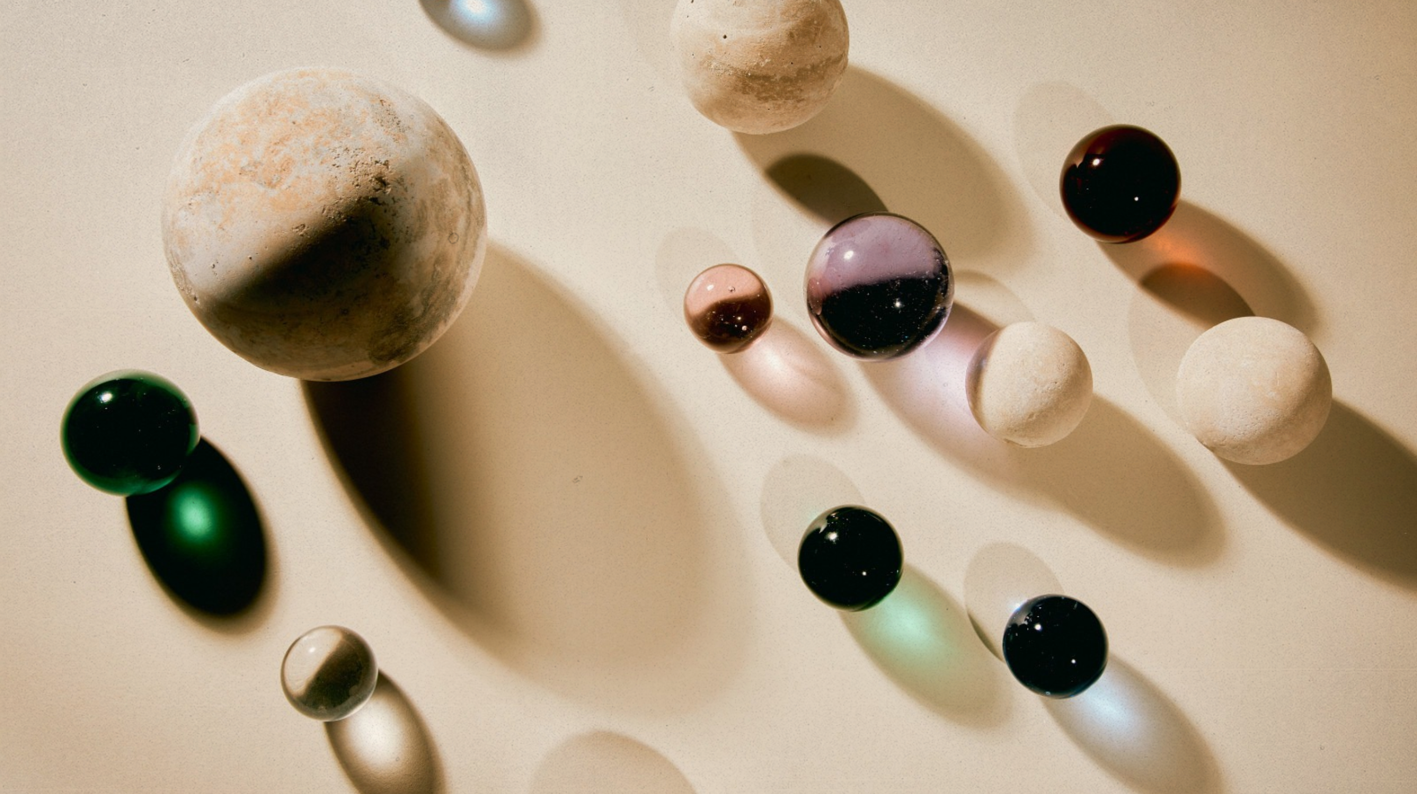 Different colour and shaped spheres on a beige background