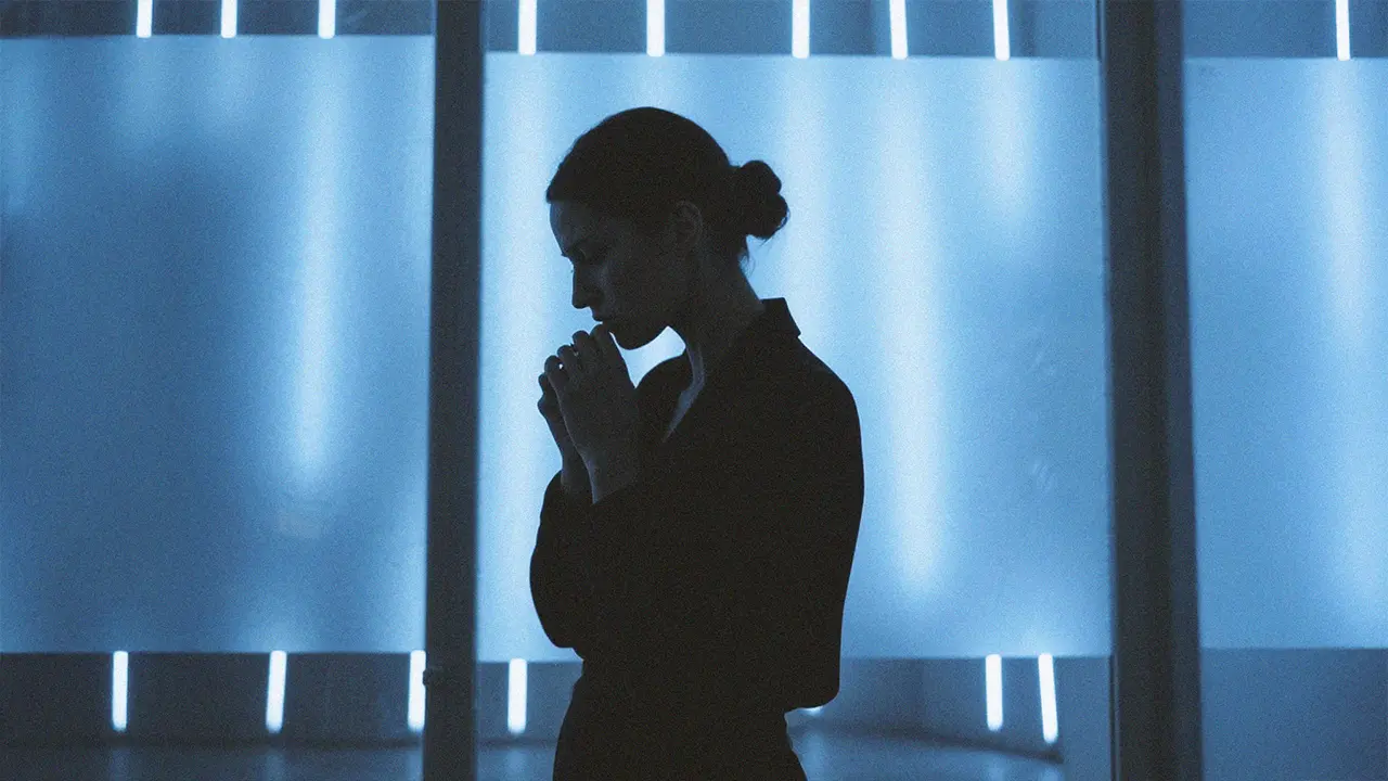 Two men and a woman in front of a light-coloured building