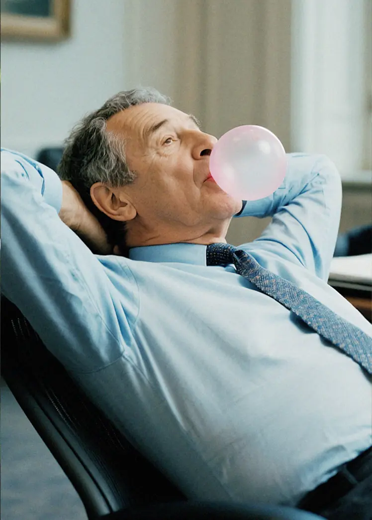 Two elderly men in suits drinking coffee.